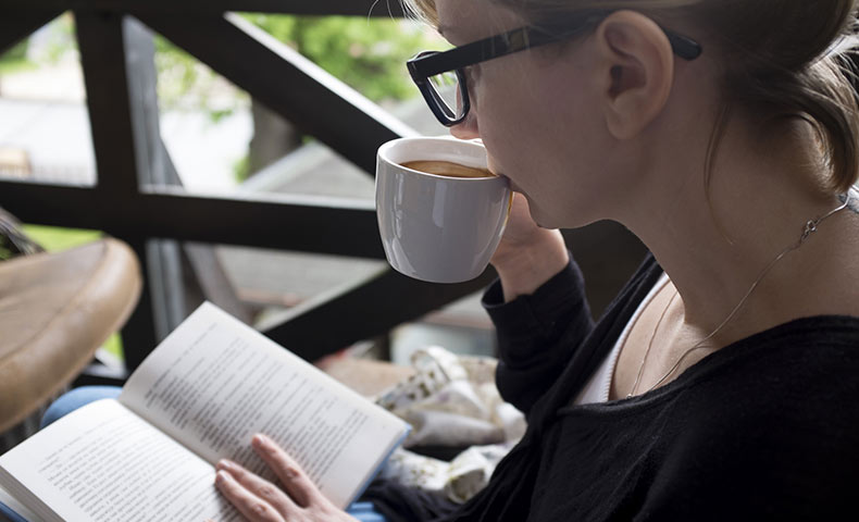 コーヒーを飲みながら読書する女性