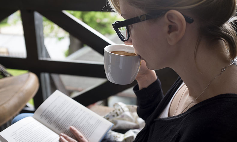 コーヒーを飲みながら読書する女性